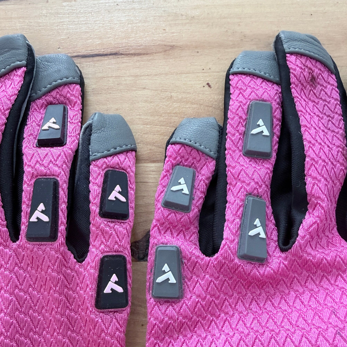 Two TRUCK Float prototype gloves side by side, finger tabs in close-up: the logo reads in opposite directions from one glove to the other